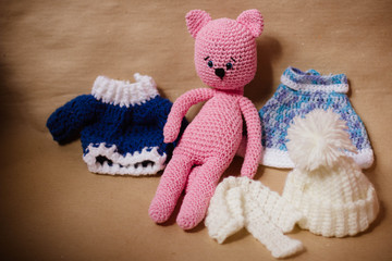 knitted pink kitty toy on a brown craft background