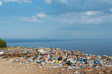 Piles of waste at landfill next to sea. Bad waste management, ecology, enviromental issues concept