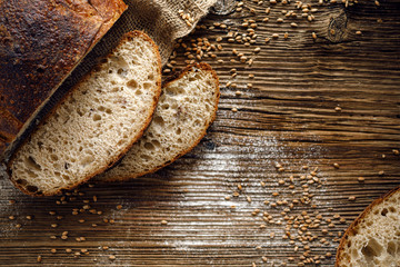 Bread,  traditional sourdough bread cut into slices on a rustic wooden background, close-up, top...