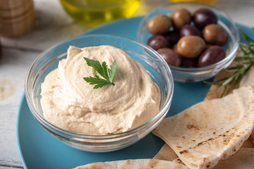 hummus with pita bread on blue plate