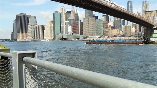 Garbage barge on the East River under the brooklyn bridge with Manhantan buidings in background