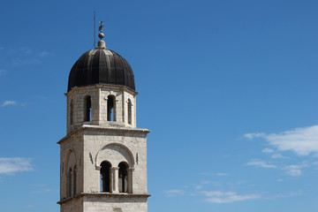 Fototapeta na wymiar Franciscan Church and Monastery bell tower close up, Dubrovnik main street, Croatia