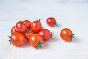 Fresh cherry tomatoes on white wooden table. Organic vegetables, healthy and dieting food, soft focus
