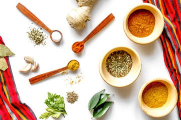 spices in wooden spoons on white background top view
