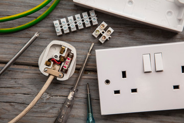 Electrical tools and equipment on a wooden background
