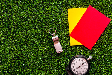 red and yellow cards on green background top view