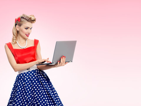 woman holding laptop, dressed in pin-up style dress