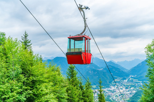 Red vintage gondola of Mount Katrin cable car and panoramic alpine view of peaks over Bad Ischl, Salzkammergut, Austria