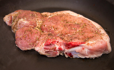 Obraz premium Fresh raw pork steak with spices roasting on frying pan