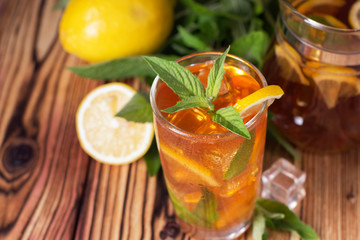 Glass of iced tea with mint and lemon. Cold drink. Rustic style