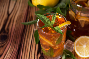 Glass of iced tea with mint and lemon. Cold drink. Rustic style
