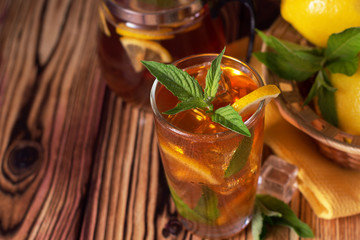 Glass of iced tea with mint and lemon. Cold drink. Rustic style
