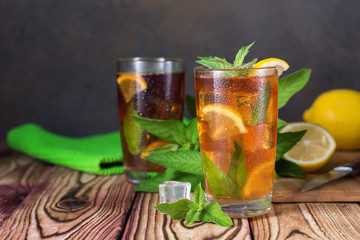 Glass of iced tea with mint and lemon. Cold drink. Rustic style
