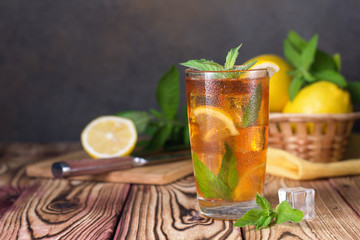 Glass of iced tea with mint and lemon. Cold drink. Rustic style