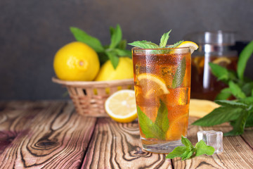 Glass of iced tea with mint and lemon. Cold drink. Rustic style