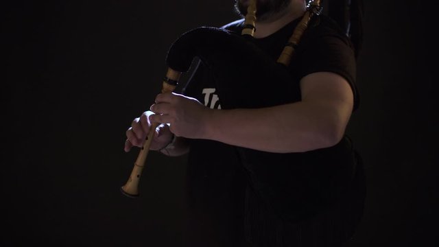 some hands play a bagpipe