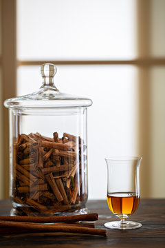 Cinnamon liquor in elegant glass and jar of cinnamon 