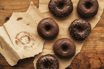 Tasty chocolate doughnuts with cream and crumbs