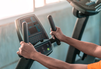 unrecognized Senior hands is working out on fitness machine for elder healthy concept