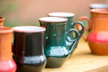 Mugs handmade from baked clay in the window at the seasonal fair masters.