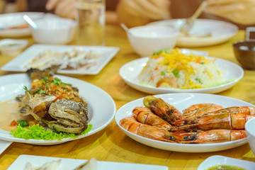 Happiness family enjoy eating with a variety of seafood dishes on dinner.
