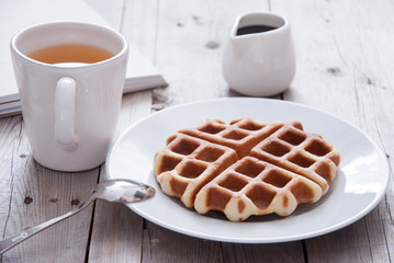 Breakfast - waffles and tea on a wooden table