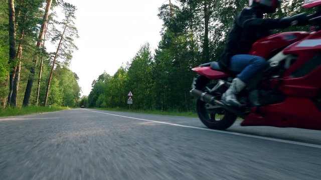 A person rides a motorbike on a road fast.