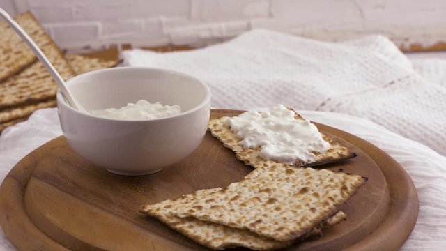Matzo with cottage cheese rotate on a wooden board.
