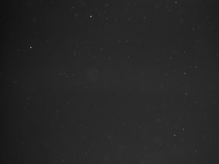 Dust particles on a dark background, abstract background