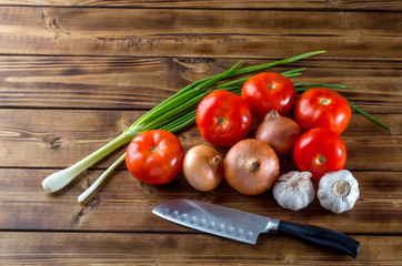 Group of raw vegetables and knife on dark wooden background