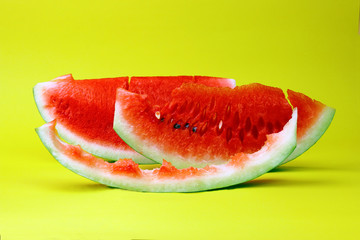 Eaten slice watermelon and watermelon slice on yellow summer background. 