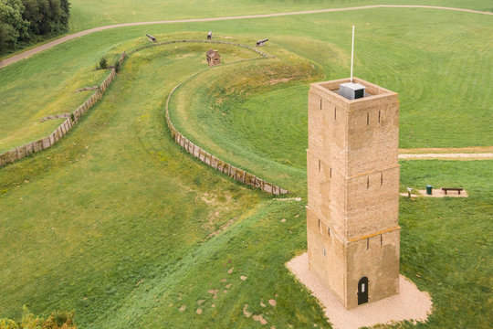 Monumental brick lighthouse or fire  light beacon called “Stenen Baak” or “Kogeloven” in Oostvoorne, Holland.  With trenches, 3 large cannons. a small gunpowder house in a grass field and walking path