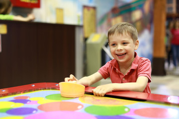 Happy boy playing air hockey