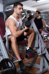 Fototapeta na wymiar Man exercising with dumbbells in gym