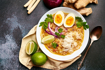 Mohinga at dark background in white plate. Mohinga is a burmese cuisine fish soup with catfish,...