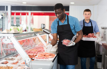 Butchers working behind counter