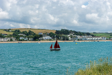 Yacht sailing up the Torridge estuary past the picturesque village of Instow in North Devon