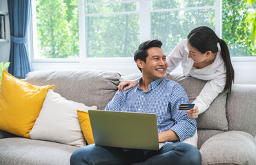 Happy Smiling Couple with Online Shopping Using Credit Card to Internet Shop on-line. Young couple...