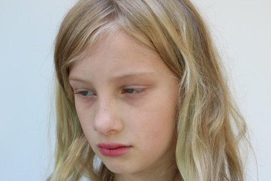 Portrait of a blonde adolescent girl looking down and away