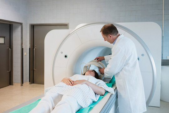 Doctor preparing patient for MRI in hospital