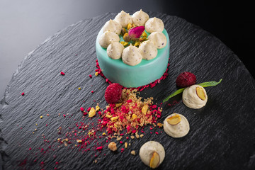 Cheesecake with raspberries and nuts on a black background