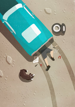 View from above of mechanic working below car