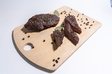 grilled beef steaks with spices on wooden cutting board