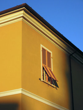 Sunlight shining on yellow building with shutters, Lerici, Liguria, Italy