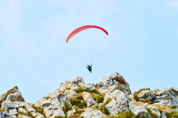 Paraglider flying over the Garda Lake (Lago di Garda or Lago Benaco). Paragliding on Monte Baldo. Panorama of the gorgeous Garda lake surrounded by mountains, Malcesine, Italy