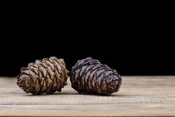 Two siberian taiga cedar cones on a wooden table. Cedar resin on a bump.