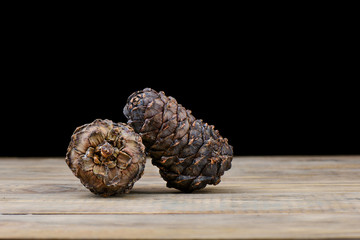 Two siberian taiga cedar cones on a wooden table. Cedar resin on a bump.