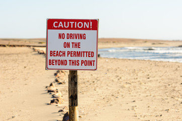 Sign warning drivers "no driving on the beach permitted beyond this point".