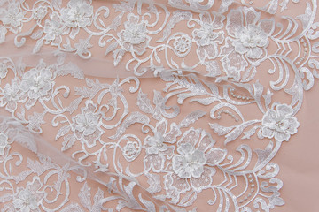 Texture lace fabric. lace on white background studio. thin fabric made of yarn or thread. a background image of ivory-colored lace cloth. White lace on beige background.