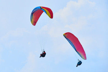 Paraglider flying over the Garda Lake (Lago di Garda or Lago Benaco). Paragliding on Monte Baldo. Panorama of the gorgeous Garda lake surrounded by mountains, Malcesine, Italy